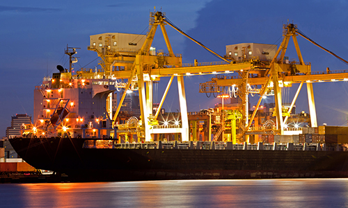 Container Cargo freight ship with working crane bridge in shipyard at dusk for Logistic Import Export background